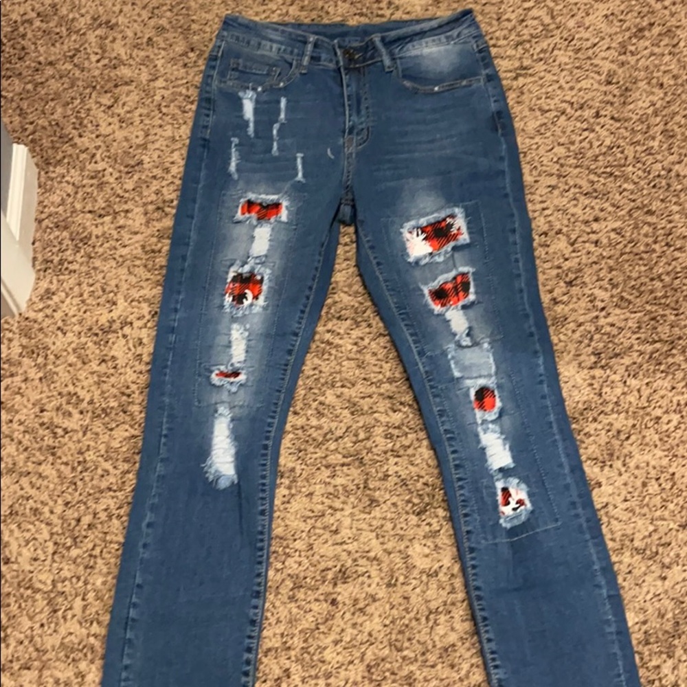 Fashoin ripped jeans with a plaid patch.